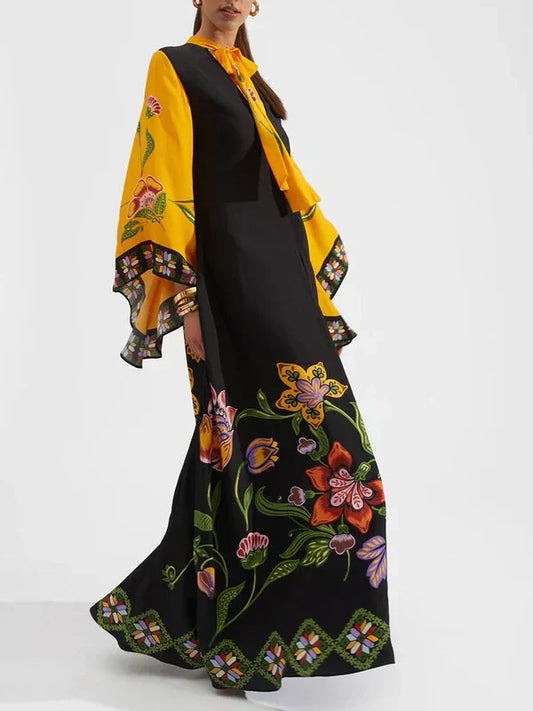 Woman wearing a black dress with floral embroidery and a yellow shawl with floral patterns on a white background